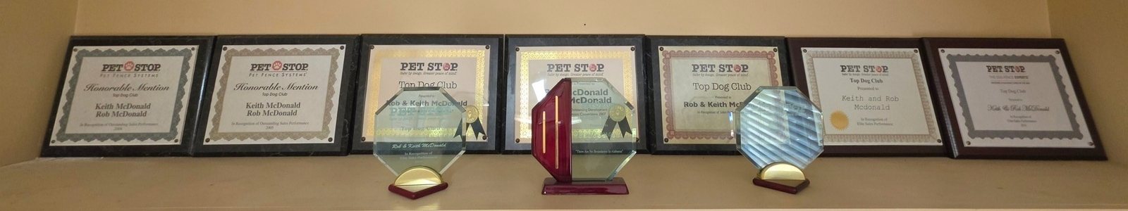 A shelf of Pet Stop awards earned by Rob and Keith McDonald over three decades