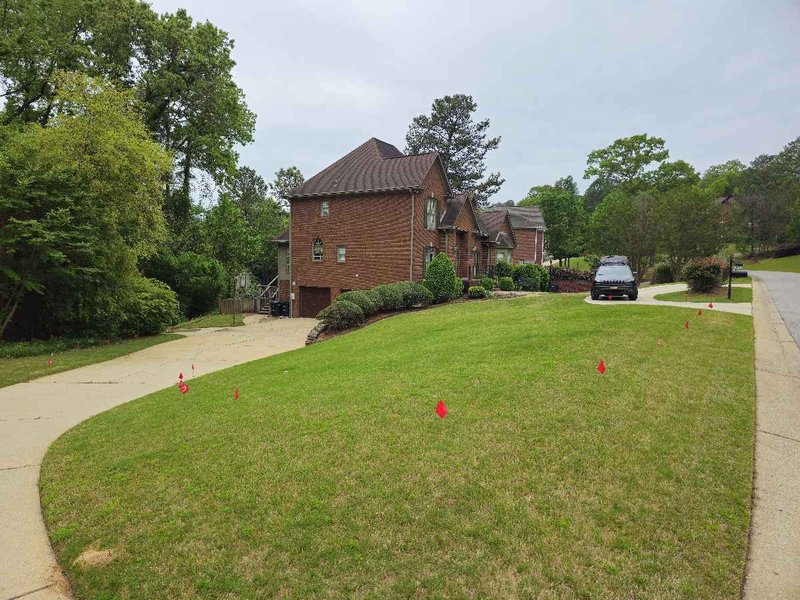 Yard with flagged boundary markers across the lawn during dog fence training